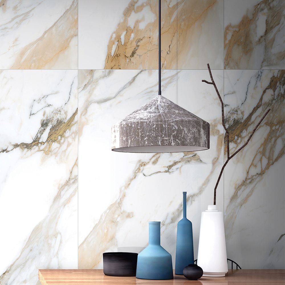 Decorative vases and a lamp against a marble wall