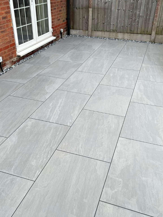 Gray patio stones laid out in a pattern on a patio area.