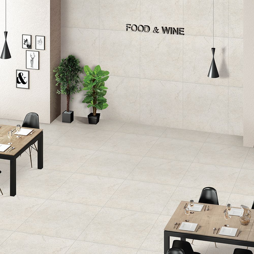 Modern restaurant interior with tiled floor and tables set for dining.