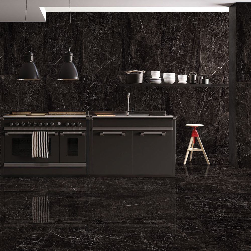 Modern kitchen with black marble walls and floor, featuring a stove and sink.
