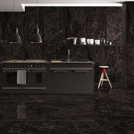 Modern kitchen with black marble walls and floor, featuring a stove and sink.
